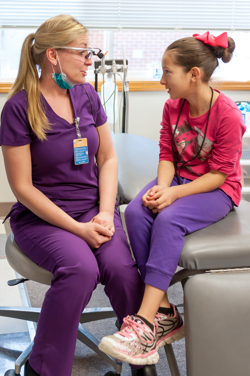 Hygienist Keela Sutton talks with a student about how to care for teeth.