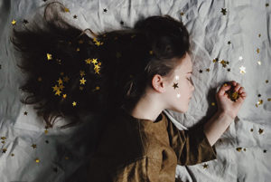 A girl sleeps amidst glittering stars