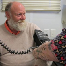A medical assistant takes Jimmy Pyle's blood pressure during a visit to the mobile center.