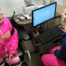 Mobile center employee Trisha Ross talks with a patient on the mobile center during a stop at Kelly Shelter in Medford.